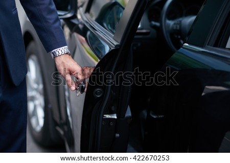 Cropped image of businessman opening door on his car