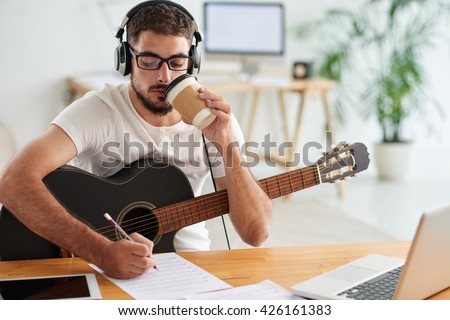 Composer drinking take-out coffee when working on new song