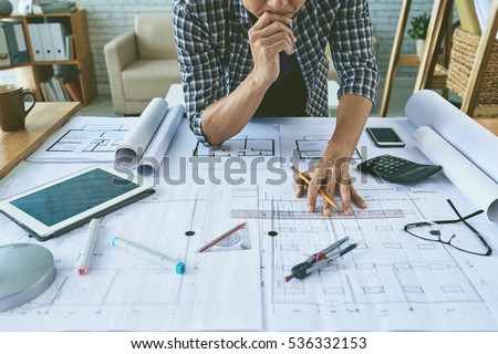 Cropped image of architect working with construction plans