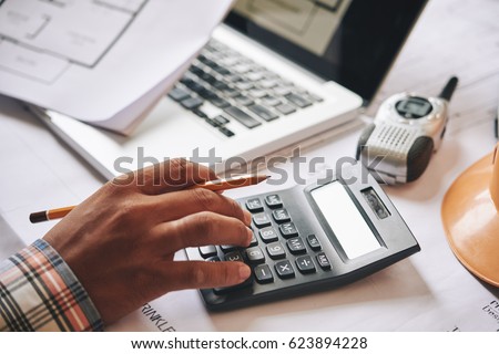 Hands of engineer calculating budget estimate for project