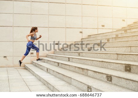Fit woman running up the stairs in the city