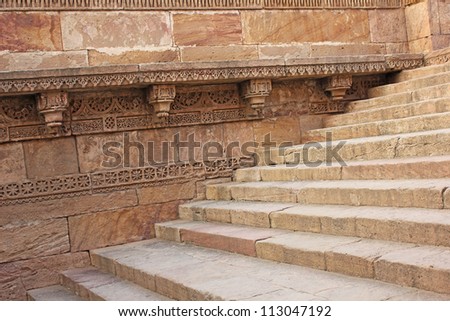 GANDHINAGAR, GUJARAT / INDIA - SEPTEMBER 2 : Adalaj Step Well ( Vav ) on September 2, 2012 in Gandhinagar. Stone carving frieze on the side walls.