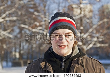 The cheerful young man against snow-covered trees