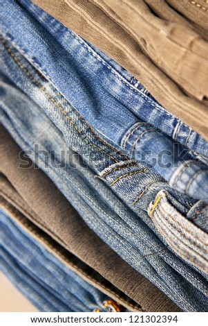 Pile of jeans of various shades on a shop counter