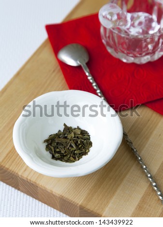Small glass mortar with a pestle on a red napkin and spice