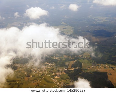 Plane view from the window on the clouds which are flying by over the earth