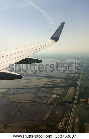 View of the ground and the wing of an airplane window