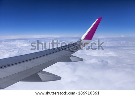 Plane view from the window on his wing and a dense bed of clouds