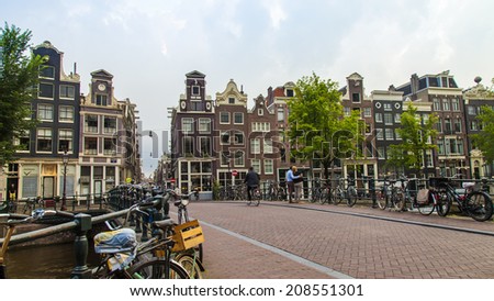Amsterdam, Netherlands, on July 12, 2014. Typical urban view with houses on the bank of the channel and the old stone bridge