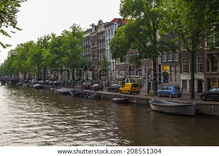 Amsterdam, Netherlands, on July 12, 2014. Typical urban view with houses on the bank of the channel and the old stone bridge