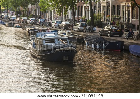 Amsterdam, Netherlands, on July 11, 2014. Walking boat are moving by the channel in the summer evening