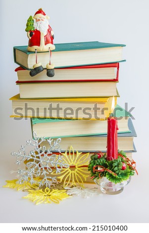 New Year\'s pile of books, jewelry for a fir-tree and the burning candle