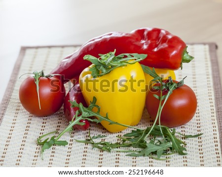 Red juicy tomatoes, leaves of arugula and sweet pepper