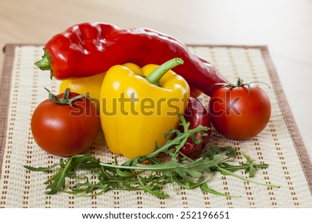 Red juicy tomatoes, leaves of arugula and sweet pepper