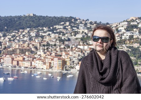Vilfransh, France, on March 10, 2015. The happy woman is photographed against a beautiful landscape, the old city and the sea