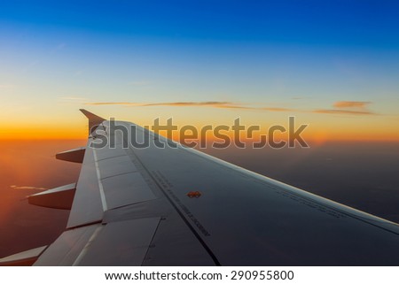 Plane view from the window on the sunset sky