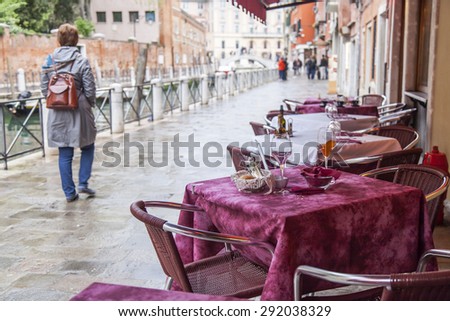 VENICE, ITALY - on MAY 1, 2015. Tables of summer cafe on the bank of the channel
