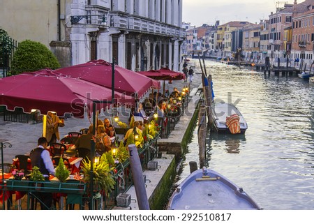 VENICE, ITALY - on MAY 1, 2015. Summer cafe on the bank of the Grand channel (Canal Grande). Numerous visitors sit at little tables
