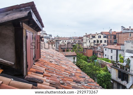 VENICE, ITALY - on MAY 3, 2015. The top view from a window of the house standing on the coast of the channel on roofs of ancient houses