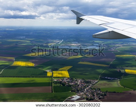 The top view from a window of the flying plane on the city and its vicinities