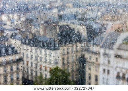 PARIS, FRANCE, SEPTEMBER 27, 2015. A view of the city from a window from a high point during a rain. Rain drops on glass. Focus on drops