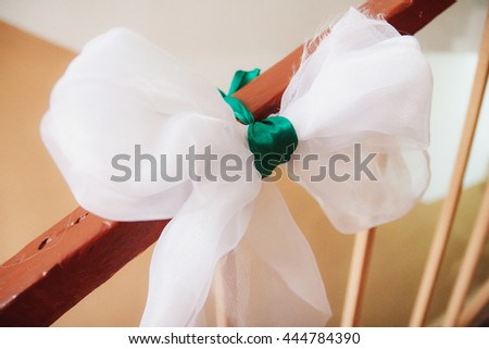 White ribbon tied on the landing with green ribbon