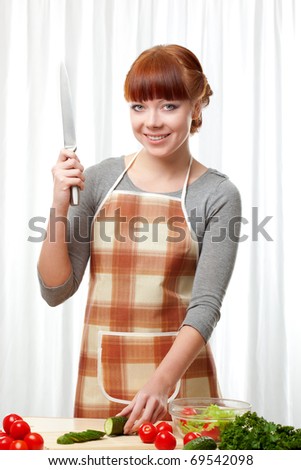 ginger woman wearing apron cooking salad over white