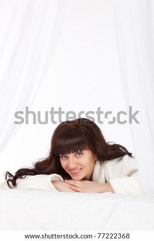 beautiful woman laying on bed behind the curtain