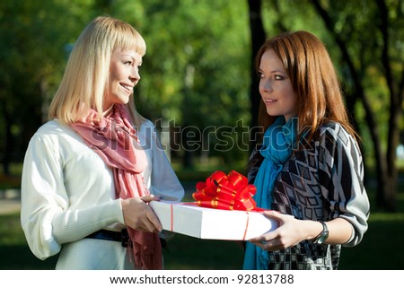 two sisters holding gift in the summer park
