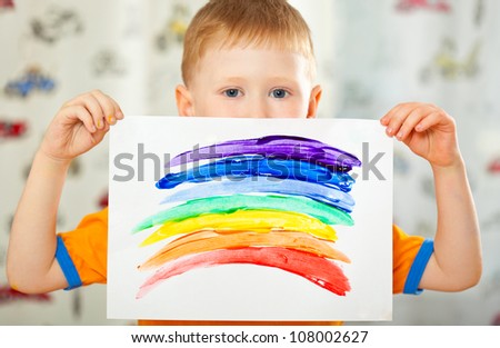 boy holding paper with painted  rainbow