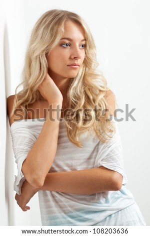beautiful blonde woman portrait near white wall