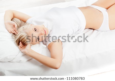 beautiful blonde woman laying on her  back  and looking at camera