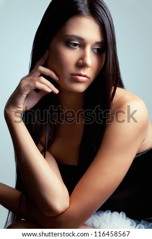 beautiful brunette woman looking down and holding her hand near head