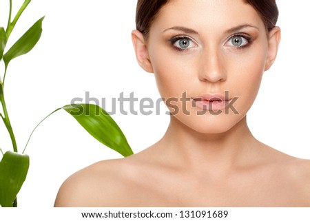 beautiful brunette woman with clear skin closeup portrait  and bamboo leaves