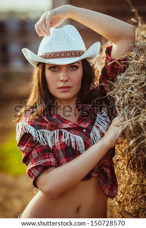 beautiful cowgirl style model posing on farmland