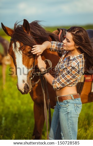 brunette cowgirl woman standing with horse outdoors portrait