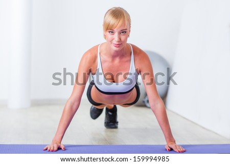 blonde woman doing push-ups on the mat