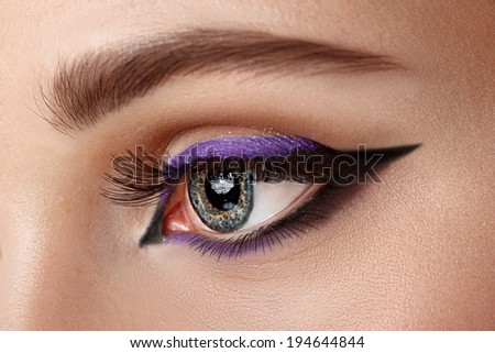 closeup woman eye with makeup - arrow black and lilac