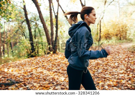 runner caucasian woman jogging in autumn park. Motion blur effect