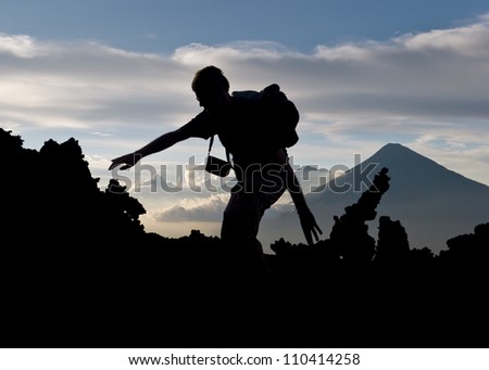 silhouette of a man climbing the top of a volcano in Antigua, Guatemala.