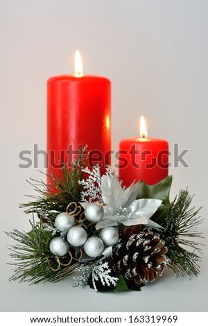 Two red candles with white and silver Christmas ornament