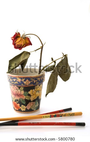 Chopsticks and vase with wilted rose isolated on white