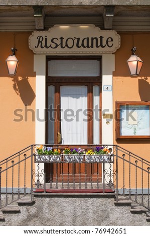 Italian restaurant door with stairs,flowers and blank menu on display