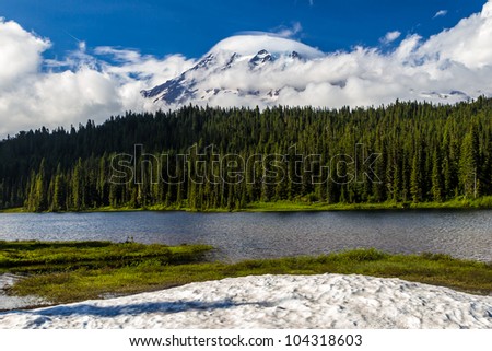 Interesting and Mystical Clouds Covering Mount Rainier at Reflection Lake with Pine Trees.