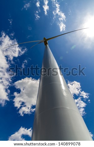 A Very Rare Straight-up Closeup Perspective of a Huge High Tech Industrial Wind Turbine, Generating Environmentally Sustainable Clean Electricity in Oklahoma.  With Blue Skies, White Clouds, and Sun.