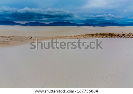 The Amazing White Sand Dunes of White Sands Monument National Park in New Mexico.  With mountains in distance.