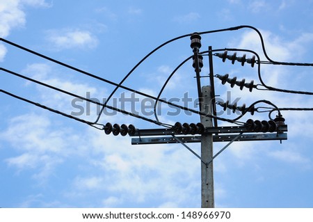 Energy and technology: electrical post on blue sky with power line cables