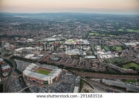 Manchester, UK - July 2014 - Twilight aerial view over Manchester with Old Trafford Football and Cricket Ground in the foreground.