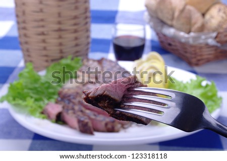 fork with morsel of meat on a plate with Florentine steak meat ,
