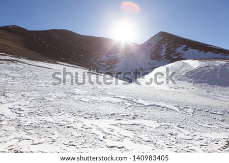 Snow mountain and sun. north-west of Lhasa near the second-largest salt lake in Tibet: it has an elevation of 5,190 m (17,030 ft).